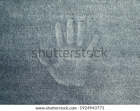 Mark of the hand on the grey velour textured surface. Palm silhouette. Concept of ghostly vision, phantom Royalty-Free Stock Photo #1924943771
