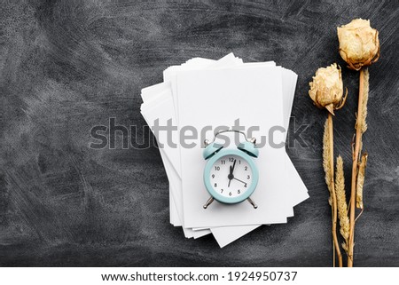 Fashionable stationery background on black - white blank postcards, alarm clock and flowers