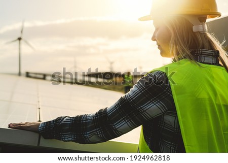 Young engineer working for alternative energy with wind turbine and solar panel - Innovation and green power concept  Royalty-Free Stock Photo #1924962818