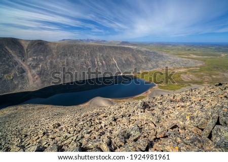 Summer arctic landscape. View from the top of the mountain to the lake, hills and endless expanses of tundra. Hard-to-reach remote polar regions in the Far North of Russia. Nature of Chukotka. Siberia