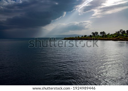 View of the Sea of Galilee or Kinneret Lake with rainy clouds and sun beams. Northern israel Royalty-Free Stock Photo #1924989446