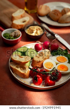 Mediterranean style breakfast plate on terracotta background. Portrait orinetation, closeup view