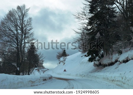 mountain road and traffic signs in the snow