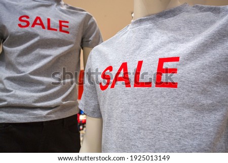 the inscription sale on the T-shirt of the mannequin in the store