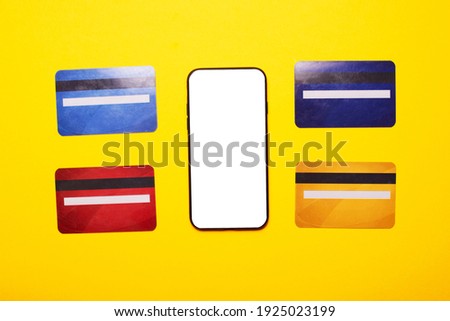 Flat lay photo of phone with white screen and many credit cards
