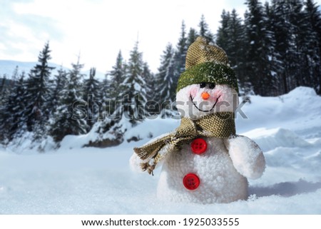 Cute small decorative snowman outdoors on sunny day, space for text