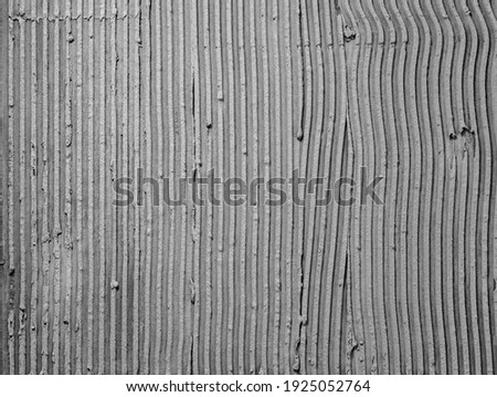Texture applied tile adhesive on wall, ribbed concrete background close-up, building material