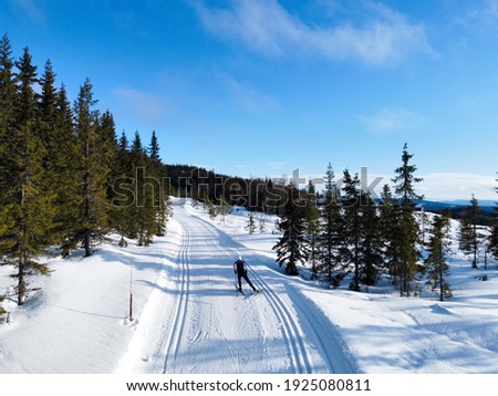 Drone picture of a teenager going cross country skiing at the mountains in Norway.