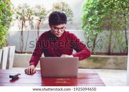 Communication and checking working hours An Asian man is working on a laptop and is devoted to planning the work. Successful businessmen Business and team work concept