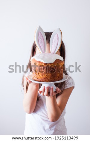Girl holding Easter cake with bunny ears
