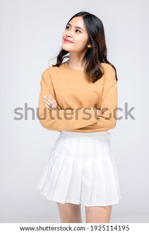 Beautiful young woman standing in casual wear , Mixed race Asian Caucasian girl. Happy face, a confident, beautiful woman isolated on a gray background.
