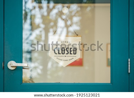 Close sign and chain hangs on a glass storefront or door due to the shop or retail business being closed during the COVID-19 outbreak ,government stay at home orders.