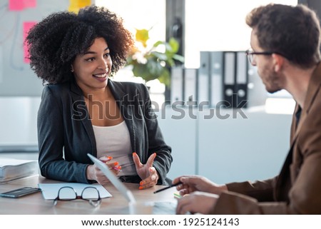 Shot of two smart multiethnic business people working together with laptop while talking about job news in the office. Royalty-Free Stock Photo #1925124143