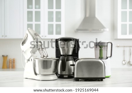 Modern toaster and other home appliances on white marble table in kitchen Royalty-Free Stock Photo #1925169044