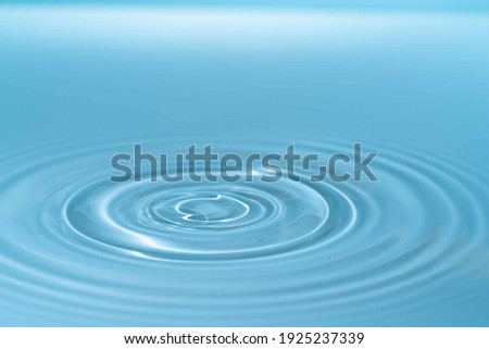 Waves on the surface of the water from a collision. Drop of water drop to the surface. Royalty-Free Stock Photo #1925237339