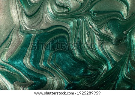 Beautiful muted turquoise stains of liquid nail polish,fluid art technique.Shimmer marble background.Liquid stripy paint texture.Nail laquer flow modern backdrop.Minimalistic concept.Copy space.