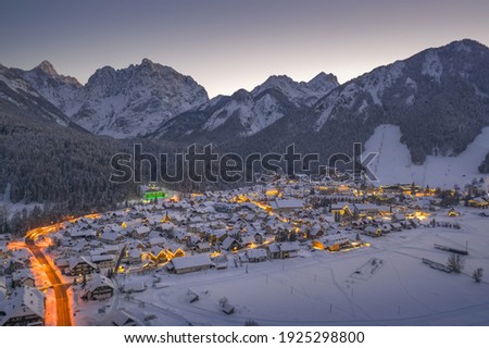 Kranjska gora in winter at night with city lights and snow. Drone shot, aerial view. Royalty-Free Stock Photo #1925298800