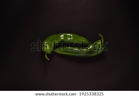 Fresh green peppers on dark background