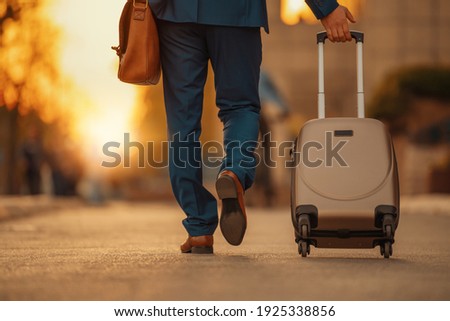 Business traveler pulling suitcase on airport.Business travel. Royalty-Free Stock Photo #1925338856