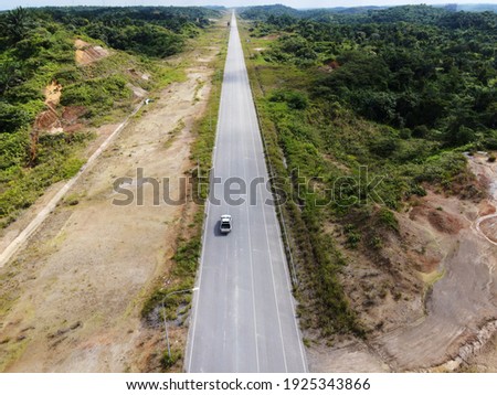 Picture of Long straight road going through the industrial zone of  tropical Sarawak, Malaysia, Southeast Asia