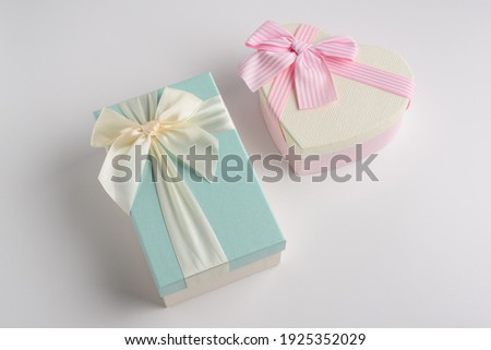 Beautiful gift boxes of different shapes in pink and turquoise colors with a ribbon and a beautifully tied bow on a white background. Festive packaging for a gift or surprise for a loved one.