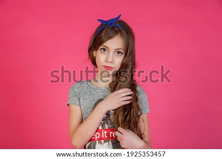Portrait 7-8 year old girl in dress on pink isolated background looks at camera. Concept Playing and Children Recreation. Little child in casual clothes posing and showing emotions. Copy space