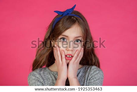 Emotional 8 year old cute teenage girl thinking and looking camera, isolated against pink background. Caucasian child in casual clothes shows surprise and unexpected event. Copy space for site