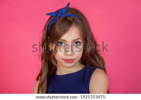 Portrait 7-8 year old girl in dress on pink isolated background looks at camera. Concept Playing and Children Recreation. Little child in casual clothes posing and showing emotions. Copy space