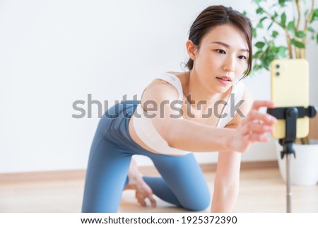 Beautiful young asian woman exercising in the room,taken pictures of her self