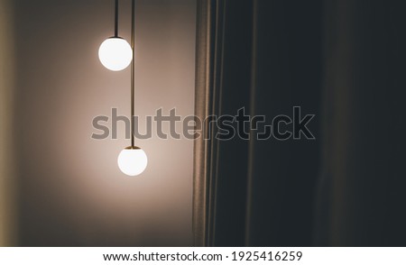 hanging ceiling light lamp decorated at corner of bedroom with grey curtain, interior concept