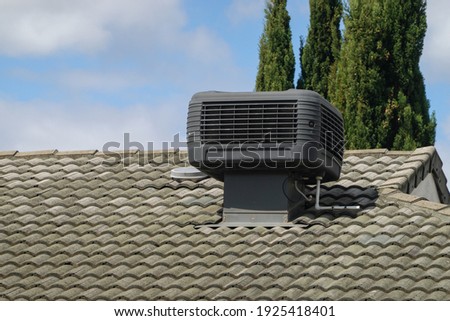 Older Style Evaporative Cooler on Roof of House Royalty-Free Stock Photo #1925418401