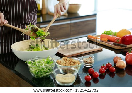 Young Asian beautiful pretty cute wife woman standing in kitchen holding vegetables show family before cooking food. cook food steak vegetables healthy work at home stay at home for safety concept