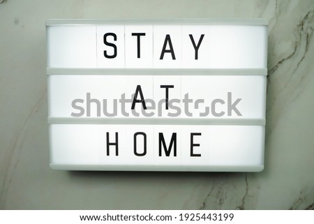 Stay at Home word letter in light box on marble background