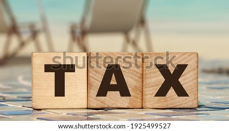 TAX letters on wooden cubes Taxes and fees business concept.