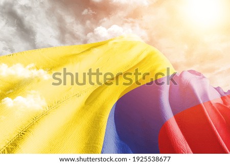 Colombia  national flag cloth fabric waving on beautiful grey sky.