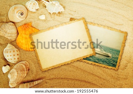 Old photo and seashells on sand.
