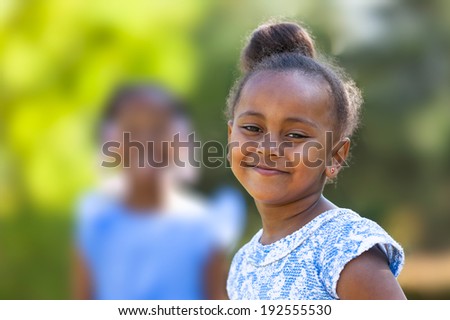 Outdoor close up portrait of a cute young black girl smiling - African people