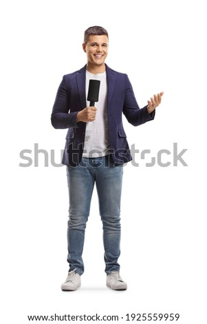 Full length portrait of male reporter holding a microphone and gesturing with hand isolated on white background
