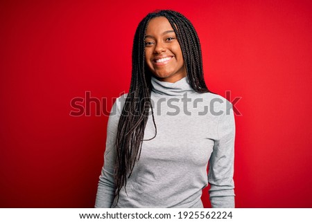 Young african american woman wearing turtleneck sweater over red isolated background with a happy and cool smile on face. Lucky person.