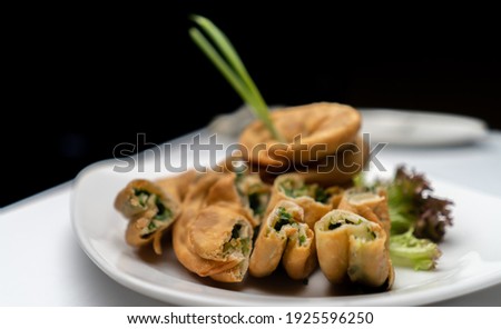 Fried Japanese vegetable dumplings with nice crisp and salad leaves. Black background on white table. Shot in landscape mode and focus on front dumplings Royalty-Free Stock Photo #1925596250