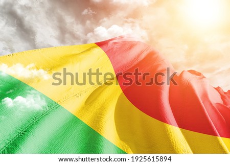 Mali national flag cloth fabric waving on beautiful grey sky.