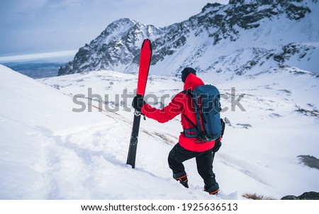 Sportsman standing with ski sticks on snow in mountains. Fantasy Adventure Composite of Man Hiking on top of a rocky mountain peak. Courage, determination, extreme sport