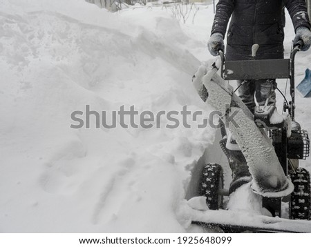 Clearing snow with a snowblower after a heavy snowfall