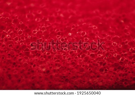 Macro photography of sponge fibers for washing dishes. The texture is red. Abstract background.