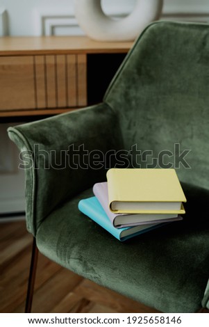 Stylish books with important events. They lie on a green chair and store memories. A stack of photo book albums with photos of different colors.