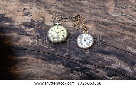 Retro pocket watch lie on a wooden background. Vintage style and filtered process.