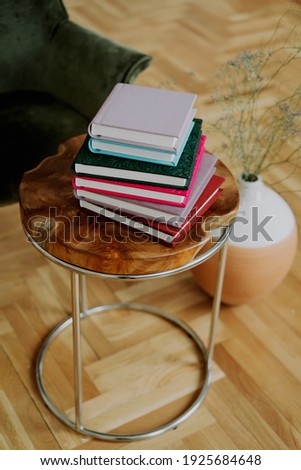 Stylish vintage books with important events. On the Table of the red wood color store memories. A stack of photo book albums with photos of different colors.