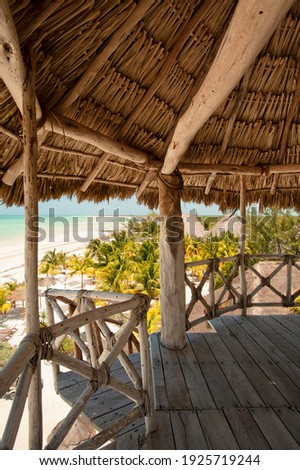 Panoramic views of the Caribbean Sea in Mexico from a wooden hut with a thatched roof. In the background the white sand beach and the Ocean.