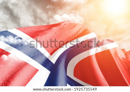 Norway national flag cloth fabric waving on beautiful grey sky.