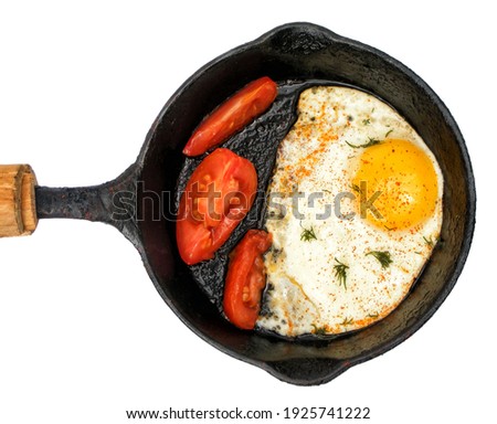 Egg and tomato in a frying pan isolated on white background
